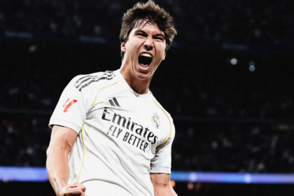 Real Madrid mengalahkan Real Betis dengan skor telak 5-1 pada pekan ke-19 La Liga 2025/2026. Duel ini berlangsung di Santiago Bernabeu, Minggu (4/1/2026) malam WIB, kick-off jam 22.15. Los Blancos tampil dominan dan memaksimalkan momentum sejak babak pertama. Gonzalo Garcia mencuri sorotan lewat hattrick, sementara gol tambahan dicetak Raul Asencio dan Fran Garcia, sedangkan Betis hanya mampu membalas lewat Cucho Hernandez. Kemenangan ini membuat Real Madrid tetap menempel ketat papan atas klasemen di posisi kedua dengan 45 poin. Real Betis harus puas tertahan di peringkat keenam dengan koleksi 28 poin. Babak Pertama Real Madrid langsung menekan sejak awal laga, dengan Vinicius Junior menjadi motor serangan dari sisi kiri. Beberapa kali Betis dipaksa bertahan dalam blok rendah untuk meredam agresivitas tuan rumah. Peluang berbahaya pertama datang pada menit ketujuh saat Vinicius terjatuh di kotak penalti, namun wasit menilai tidak ada pelanggaran. Tekanan berlanjut dan membuat lini belakang Betis bekerja ekstra keras. Kebuntuan pecah pada menit ke-20 melalui situasi bola mati. Rodrygo mengirimkan umpan bebas terukur ke tiang jauh, disambut sundulan Gonzalo Garcia yang mengarah ke sudut bawah gawang tanpa mampu dihalau Alvaro Valles. Setelah unggul, Madrid tetap mendominasi penguasaan bola, meski beberapa peluang dari Camavinga dan Tchouameni belum membuahkan hasil. Betis sesekali merespons lewat tembakan jarak jauh Nelson Deossa. Peluang terbaik Betis di babak pertama hadir menjelang turun minum melalui sundulan Cucho Hernandez. Namun, arah bola masih melebar dan tak cukup menguji Thibaut Courtois. Hingga tambahan waktu berakhir, Madrid mempertahankan keunggulan 1-0 dengan kontrol permainan yang relatif aman. Babak Kedua Madrid membuka babak kedua dengan tempo tinggi dan langsung menggandakan keunggulan pada menit ke-50. Federico Valverde mengirim umpan akurat yang dikontrol Gonzalo Garcia sebelum diselesaikan dengan tembakan keras ke pojok gawang. Tekanan tuan rumah berlanjut dan berbuah gol ketiga enam menit kemudian. Dari sepak pojok Rodrygo, Raul Asencio menyundul bola dengan sempurna ke sudut atas gawang Betis. Real Betis sempat bangkit dan memperkecil ketertinggalan pada menit ke-66. Cucho Hernandez memanfaatkan kesalahan koordinasi lini belakang Madrid, melewati Courtois, lalu mencetak gol ke gawang kosong. Momentum Betis nyaris berlanjut ketika Rodrigo Riquelme dan Giovani Lo Celso sama-sama membentur tiang gawang. Namun, Madrid bertahan dengan disiplin dan kembali mengambil alih kendali. Pada menit ke-82, Gonzalo Garcia memastikan hattrick setelah menerima assist Arda Guler dan menyelesaikannya dengan sentuhan cerdas ke sudut gawang. Gol ini praktis mematikan perlawanan Betis. Pesta gol ditutup pada masa injury time ketika Fran Garcia menuntaskan umpan silang Valverde di tiang jauh. Skor 5-1 bertahan hingga laga usai, menandai malam sempurna bagi pasukan Xabi Alonso.