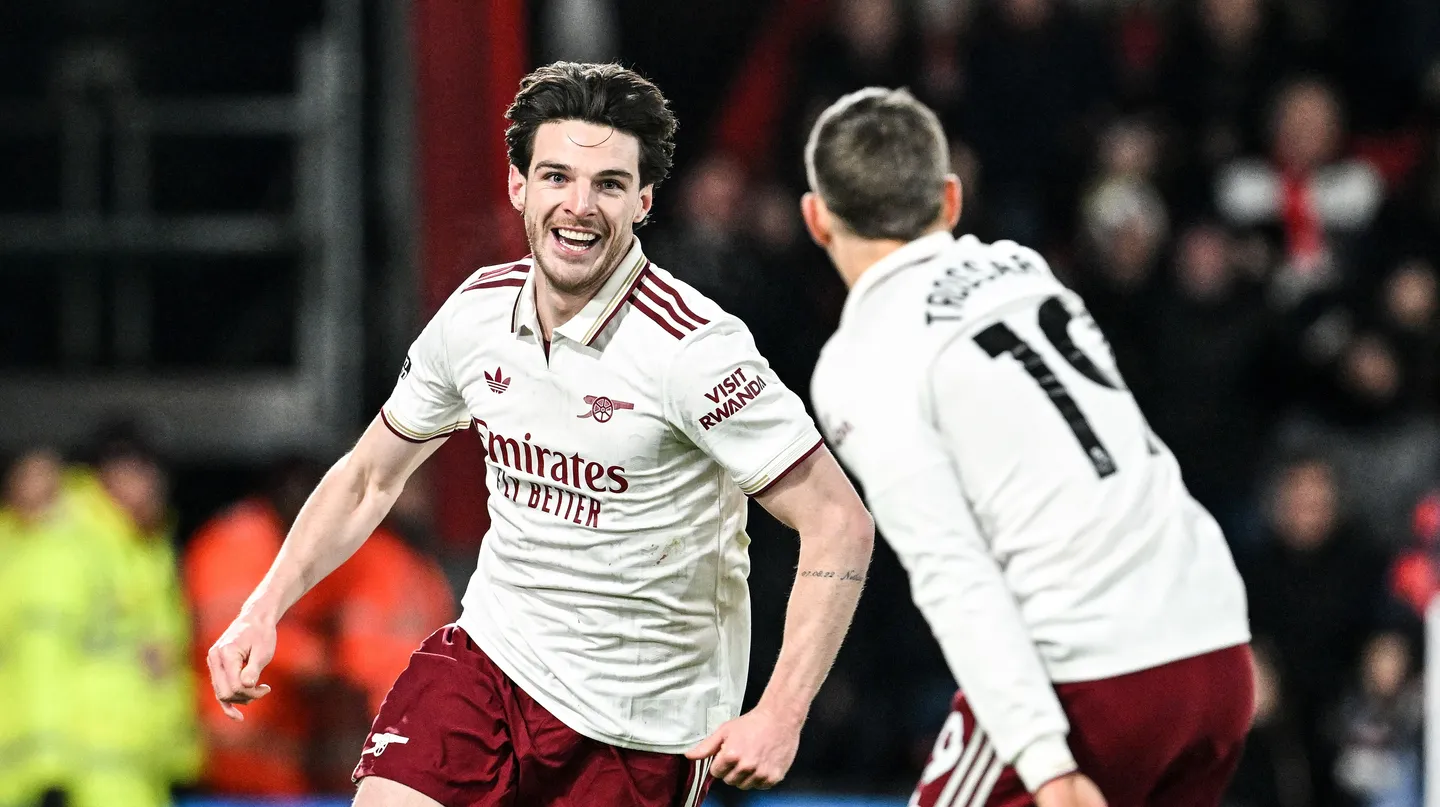 Arsenal menang dengan cukup dramatis saat berduel lawan Bournemouth di pekan ke-20 Liga Inggris 2025/2026 di Vitality Stadium, Minggu (04/01/2026). Bournemouth membuat kejutan saat Evanilson bisa mencetak gol lebih dahulu. Ia memanfaatkan blunder Gabriel Magalhaes. Namun bek asal Brasil itu menebus kesalahannya dan membuat skor berimbang 1-1. Setelah itu Declan Rice mencetak dua gol dan membuat Arsenal dalam posisi unggul 1-3. Bournemouth sempat mencetak satu gol lagi melalui tembakan keras Eli Junior Kroupi. Namun Arsenal akhirnya bisa mengamankan kemenangan dengan skor 2-3. Berikut rapor pemain Arsenal di pertandingan tersebut. Rapor Pemain Belakang dan Kiper David Raya: 6 Kiper asal Spanyol itu praktis tak punya banyak pilihan saat gol pembuka tercipta. Sepakan Kroupi terlalu cepat dan sulit dijangkau, meski Raya nyaris bereaksi dengan penyelamatan refleks. Jurrien Timber: 7.5 Timber tampil sigap dengan tekel krusial di dekat garis gawang yang langsung berujung serangan balik. Ia juga melakukan intervensi terakhir yang sempurna untuk menggagalkan peluang emas David Brooks. William Saliba: 6.5 Bek Prancis ini tidak bisa berbuat banyak pada momen gol Bournemouth. Namun, ia tetap tenang dan cukup solid saat menghadapi tekanan tuan rumah sepanjang laga. Gabriel Magalhaes: 7 Awal laga menjadi mimpi buruk bagi Gabriel setelah kesalahan umpannya berujung gol gratis untuk Evanilson. Ia menebusnya dengan sempurna lewat gol yang menghidupkan kembali Arsenal. Piero Hincapie: 6 Dipercaya mengisi posisi bek kiri, Hincapie beberapa kali kerepotan menghadapi kecepatan Semenyo. Ia cukup sering kalah duel hingga peluit akhir berbunyi. Rapor Pemain Tengah Martin Zubimendi: 6 Zubimendi sempat kehilangan bola di awal pertandingan sebelum perlahan menemukan ritmenya. Kartu kuning membuatnya harus bermain ekstra hati-hati hingga akhir laga. Declan Rice: 9 Meski absen di laga tengah pekan, Rice langsung dipercaya sebagai starter di pantai selatan. Ia menjadi pembeda lewat dua gol krusial, termasuk sepakan rendah yang mematikan. Martin Odegaard: 8 Kapten Arsenal ini aktif mencari ruang di antara lini lawan, meski Bournemouth tampil disiplin. Satu assist yang ia ciptakan dan keterlibatannya dalam gol ketiga Arsenal kembali menegaskan pengaruh besarnya dalam permainan tim. Rapor Pemain Depan Noni Madueke: 7 Madueke menyia-nyiakan peluang emas di awal laga dengan tembakan yang melambung. Namun, pergerakannya dari sisi kanan berperan penting dalam terciptanya gol penyeimbang. Viktor Gyokeres: 5 Penyerang bernomor punggung 14 itu kembali kesulitan memberi ancaman berarti di lini depan. Selain kontribusi fisik saat proses gol, ia nyaris tak terlihat sepanjang pertandingan. Gabriel Martinelli: 7 Martinelli kerap unggul duel melawan Alex Jimenez di sisi kiri. Sayangnya, akurasi umpan akhirnya belum maksimal meski kontribusi udaranya krusial dalam build-up gol kedua. Rapor Pemain Pengganti Gabriel Jesus: 6 Jesus tampil sebagai pengganti Gyokeres pada menit ke-67 dan memberi dinamika berbeda di lini serang. Ia hampir mencetak gol lewat tembakan telat yang masih bisa ditepis Petrovic. Leandro Trossard: 6 Masuk menggantikan Martinelli pada menit ke-67, Trossard langsung memberi energi tambahan. Ia sempat menciptakan beberapa situasi berbahaya meski belum berbuah gol. Bukayo Saka: 7.5 Saka langsung memberi dampak instan usai masuk dari bangku cadangan usai menggantikan Madueke pada menit ke-67. Assist cerdasnya membantu Rice menuntaskan gol ketiga Arsenal. Mikel Merino: 6 Merino menggantikan Odegaard di menit ke-80. Ia sempat mencoba peruntungan lewat tembakan jarak jauh yang masih mampu diamankan kiper lawan.